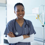portrait of happy african american female doctor in hospital room. medicine, healthcare and medical services, unaltered.