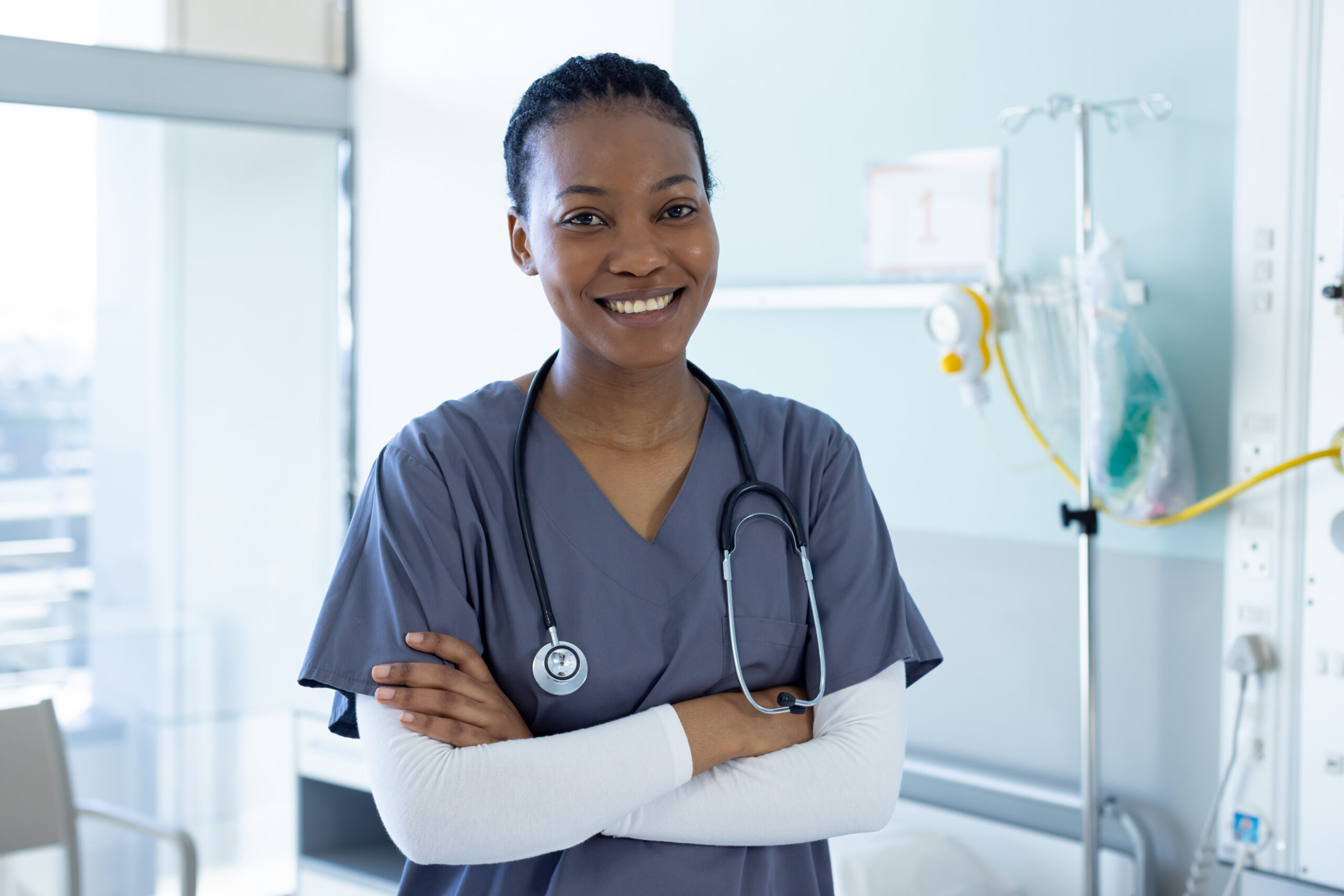 portrait of happy african american female doctor in hospital room. medicine, healthcare and medical services, unaltered.