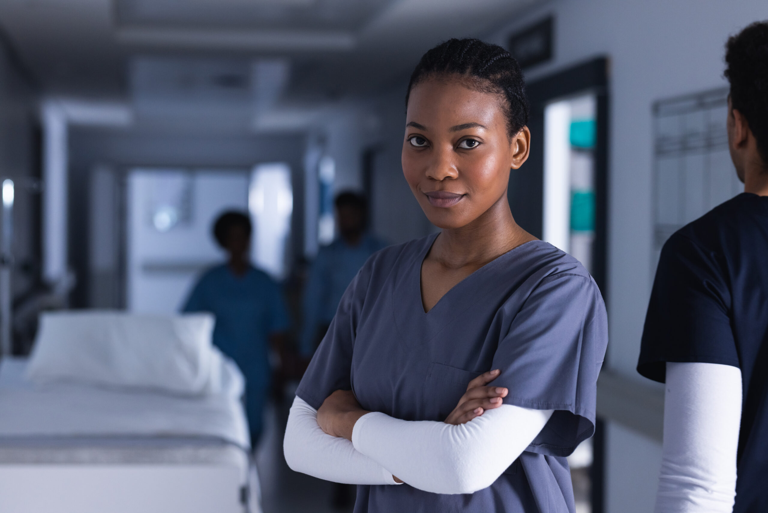portrait of happy african american female doctor in hospital corridor. medicine, healthcare and medical services, unaltered.